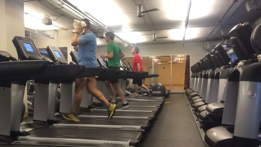 runners on treadmills inside gym.