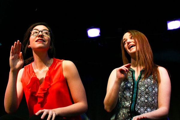 Katie Tyner and Cat Ring bring the crowd to laughter in a sketch that mentions a podcast that covers "women's issues without being too women's rights-y." (Courtesy of The Crowd Theater) 