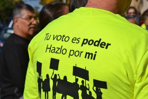 Society of Toribio Romo shirts say "Your vote is power. Do it for me" in Spanish.