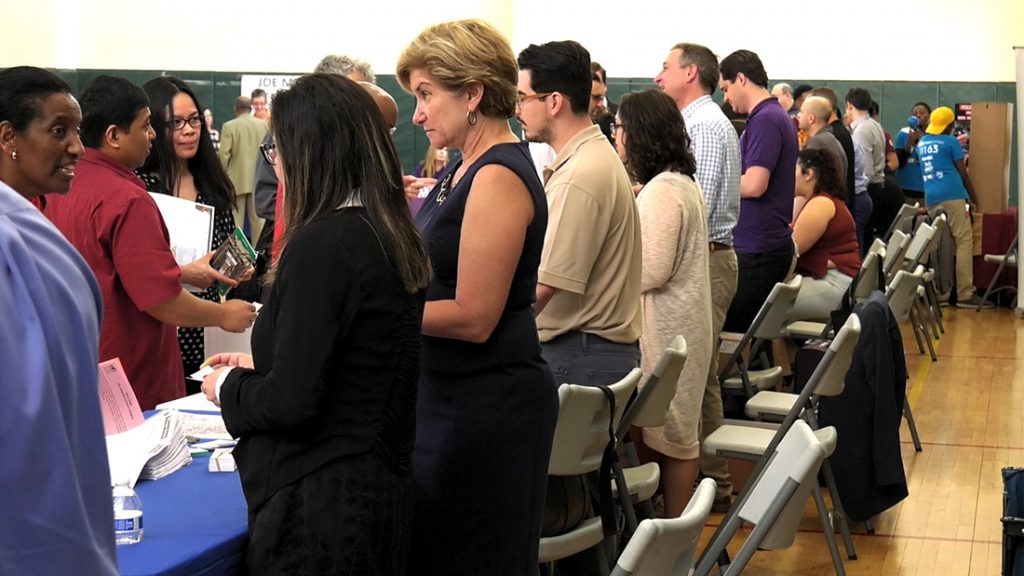 Employers talk to Chicagoans at a rogers Park job fair. Forty companies attended the fair, hosted by the City of Chicago. (Rothman/MEDILL)
