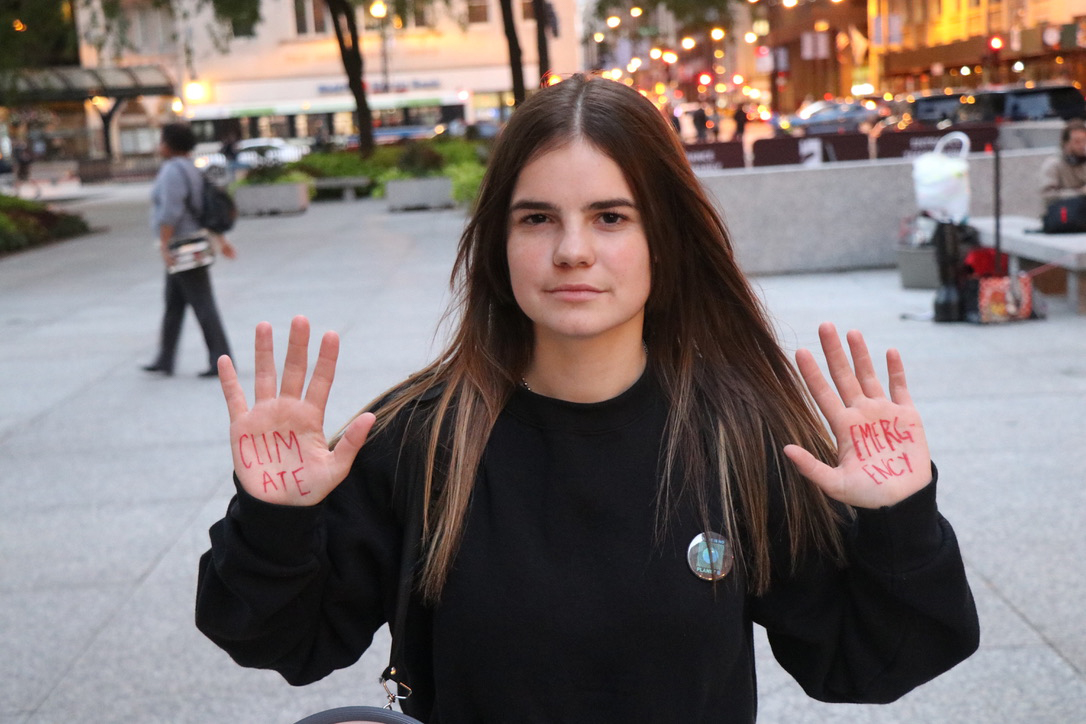 Isabella Johnson shows the phrase “climate emergency” written on her hands after leading the Oct. 7 protest. (Zack Fishman/MEDILL)